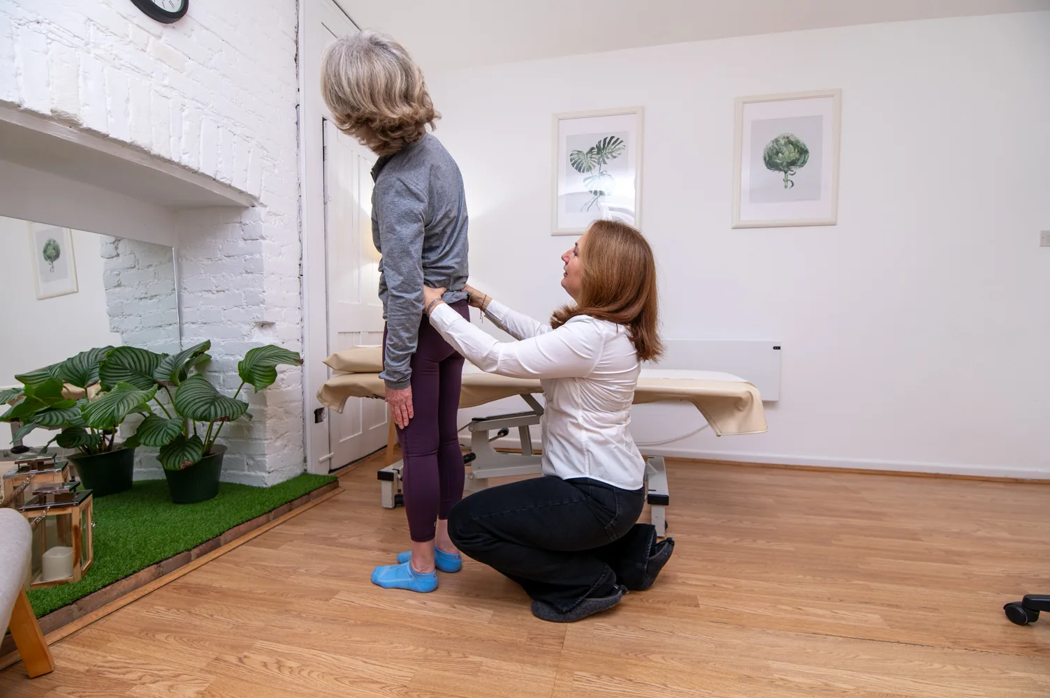 Galina Bell assessing a patient's posture at the clinic